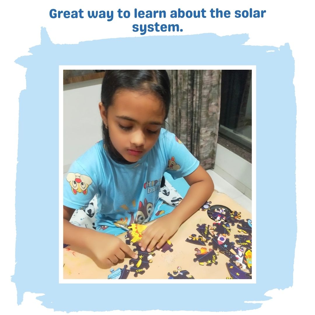 Girl playing with solar system puzzle on table